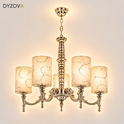 A six-light brass chandelier with decorative scrollwork and cylindrical glass shades featuring a delicate gold leaf pattern, shown against a solid white background.