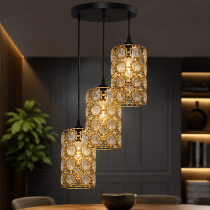 Three-tiered gold and crystal pendant light hanging in a modern dining room setting.