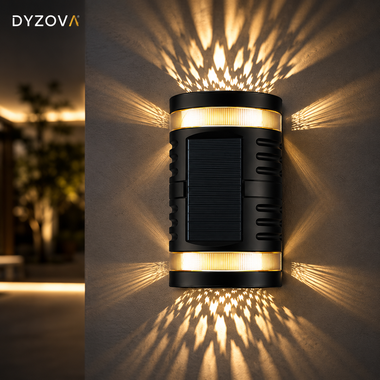 A cylindrical black outdoor wall sconce with a solar panel on the front, mounted on a textured wall. It emits warm yellow light in horizontal bands and projects starburst patterns onto the wall.
